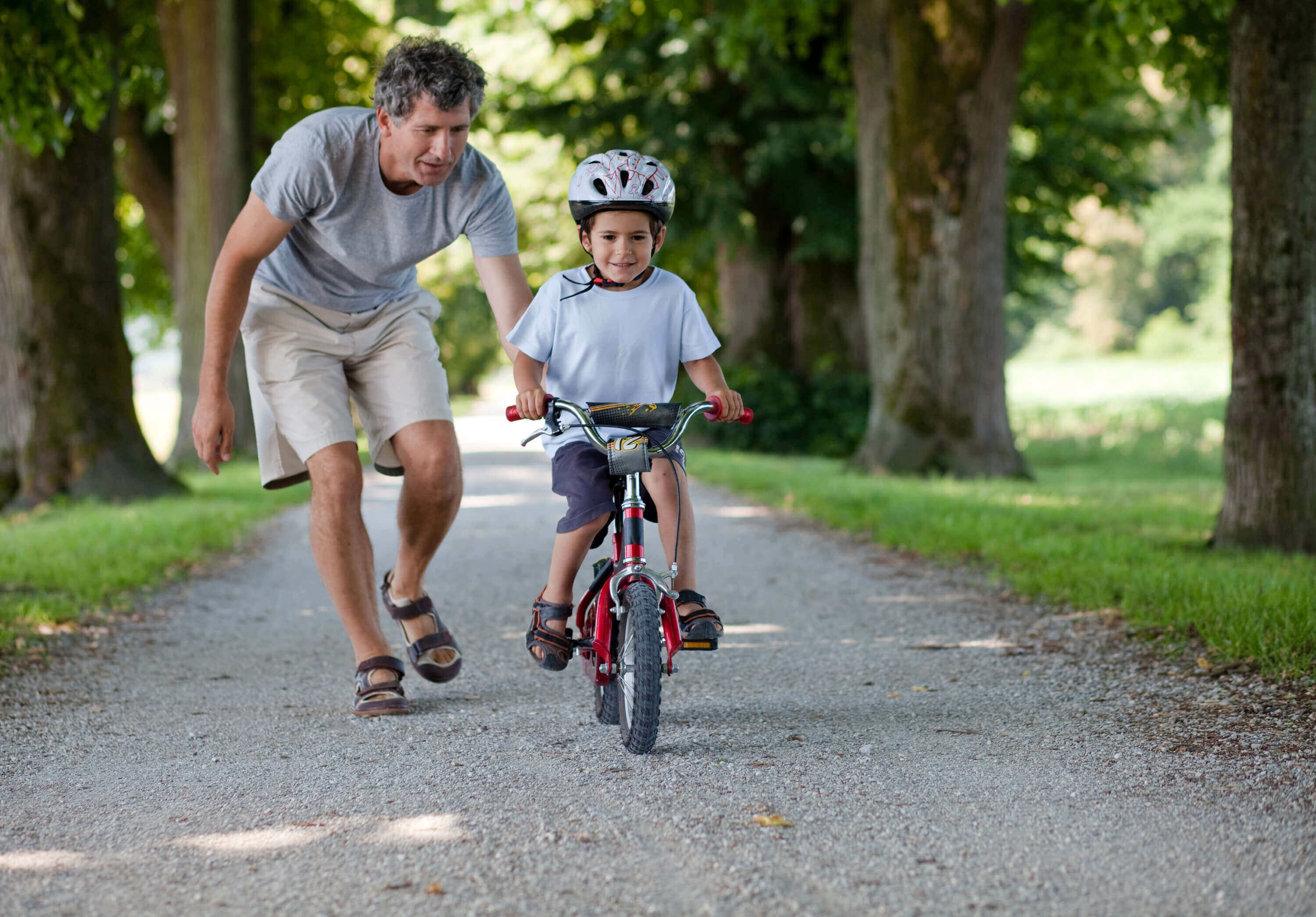 Child riding a bike in Norman, while father with sole legal custody guides him